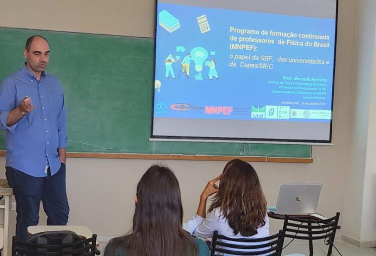 Professor Marcello Ferreira dando aula usando um projetor.